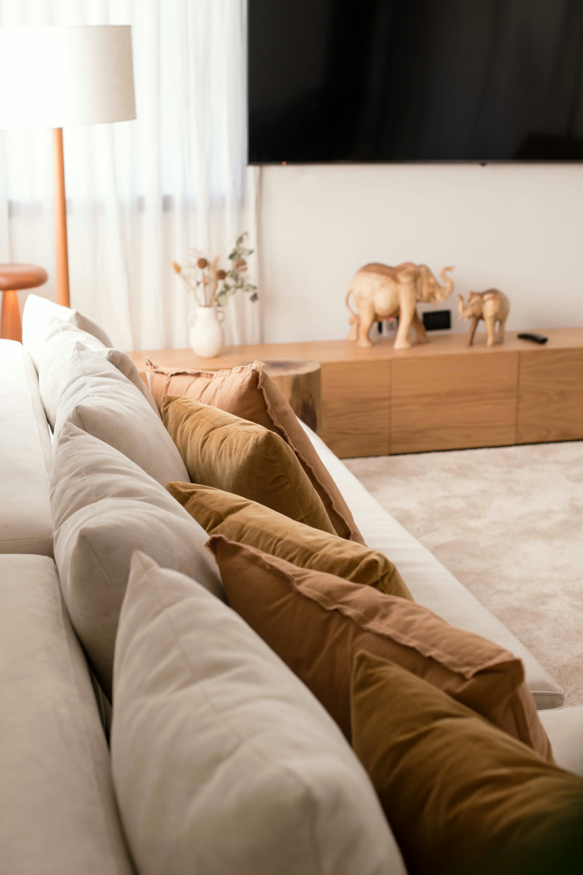 Detalle de sillón con almohadones y mueble de madera en un living