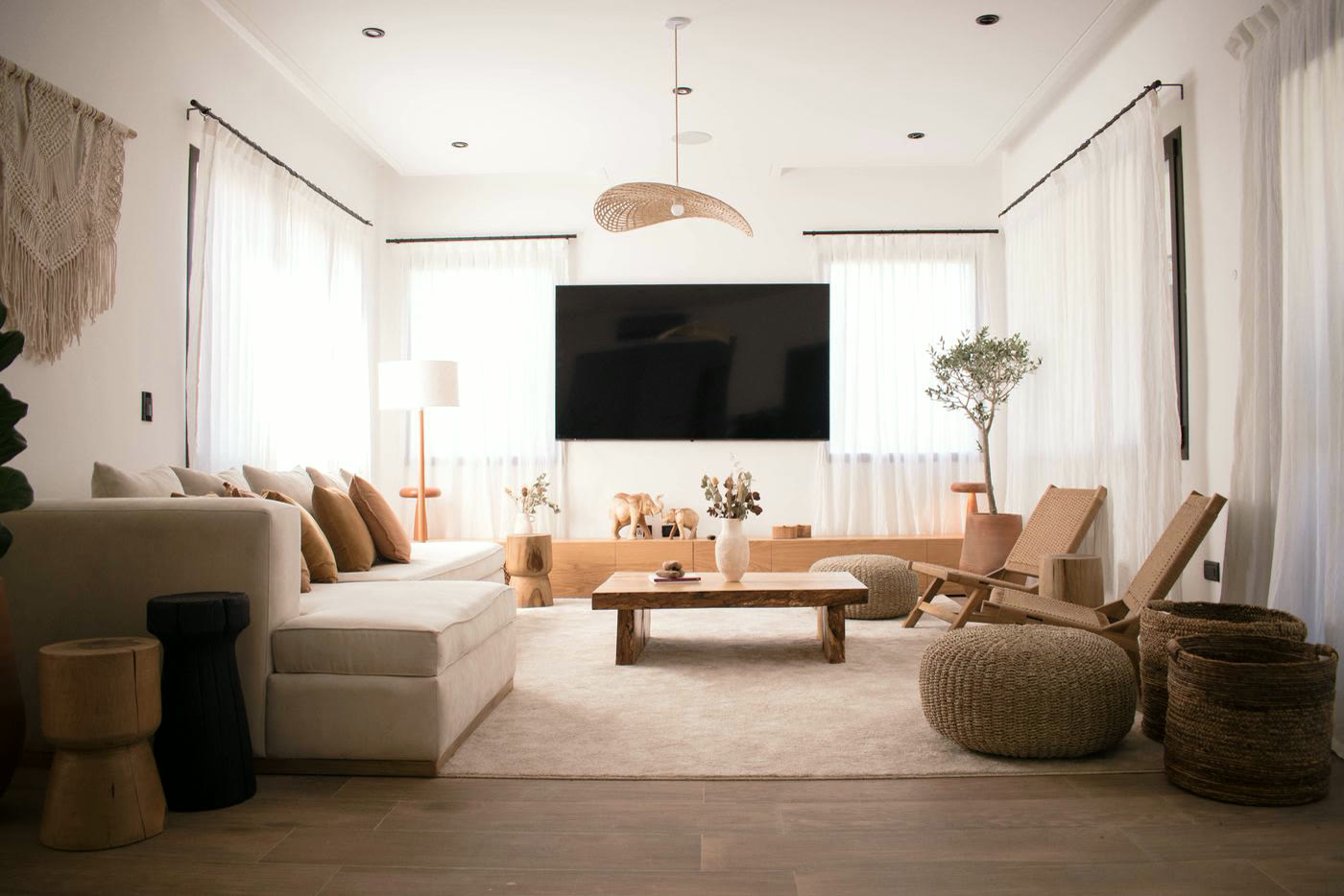 Living amplio con sillón, mesa ratona de madera y cortinas de lino